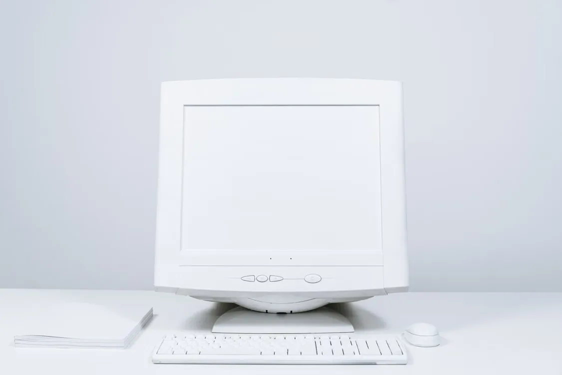 Computer desktop con monitor, tastiera e mouse su una superficie chiara